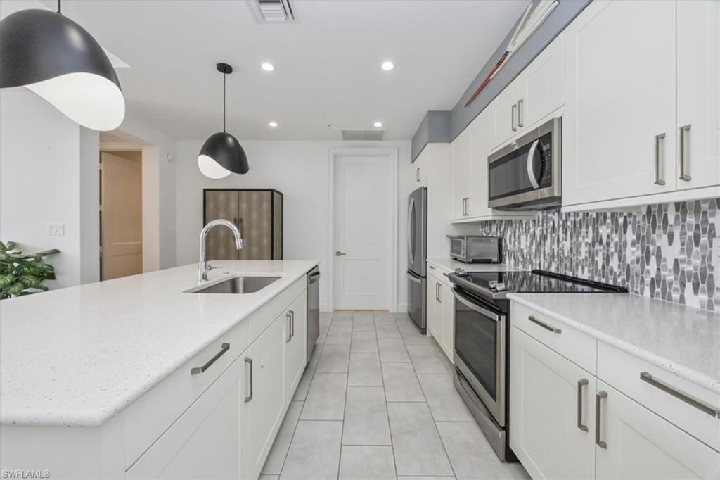 1111 Central Avenue, Unit 401 Naples, FL 34102 - Photo 8 of 36 a large kitchen with stainless steel appliances granite countertop a sink a stove and a refrigerator