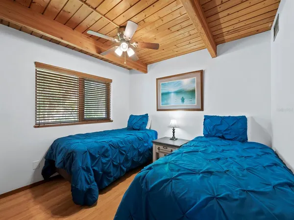 a bedroom with two beds and a chandelier