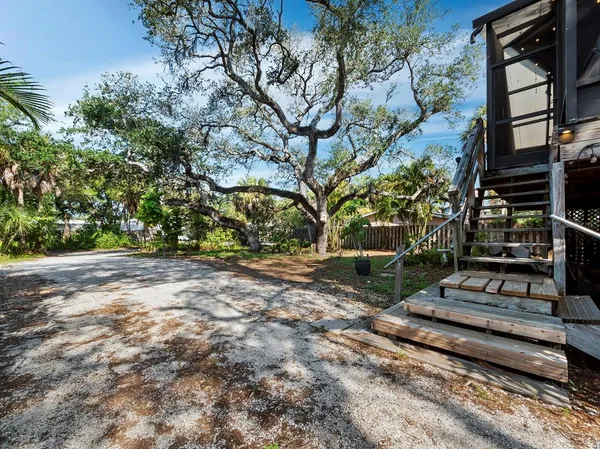 a backyard of a house with barbeque oven and trees