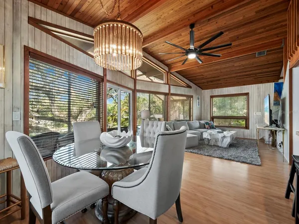a dining room with furniture wooden floor and a chandelier