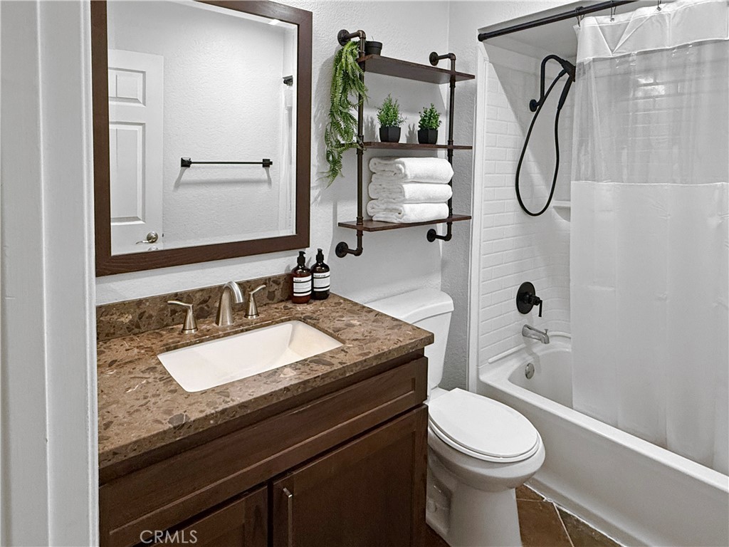 16955 Lake Knoll Parkway Riverside, CA 92503 - Photo 29 of 42 a bathroom with a granite countertop sink a toilet and shower