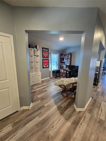 a living room with furniture a flat screen tv and kitchen view
