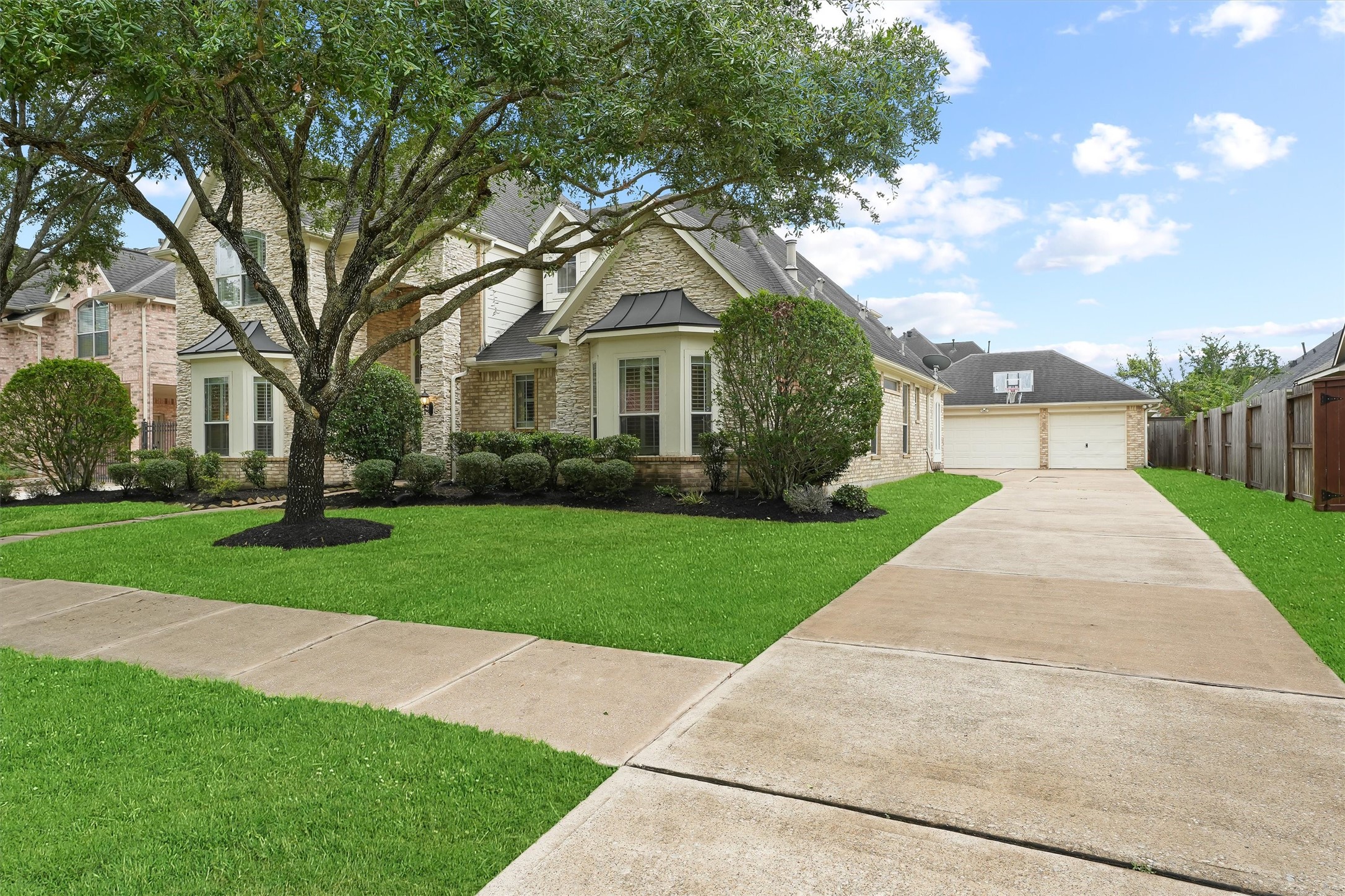 2818 Shallow Springs Court Manvel, TX 77578 - Photo 3 of 41 a front view of a house with a garden and trees