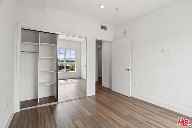 a view of a kitchen with wooden floor and a refrigerator
