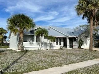 a front view of a house with a garden and tree