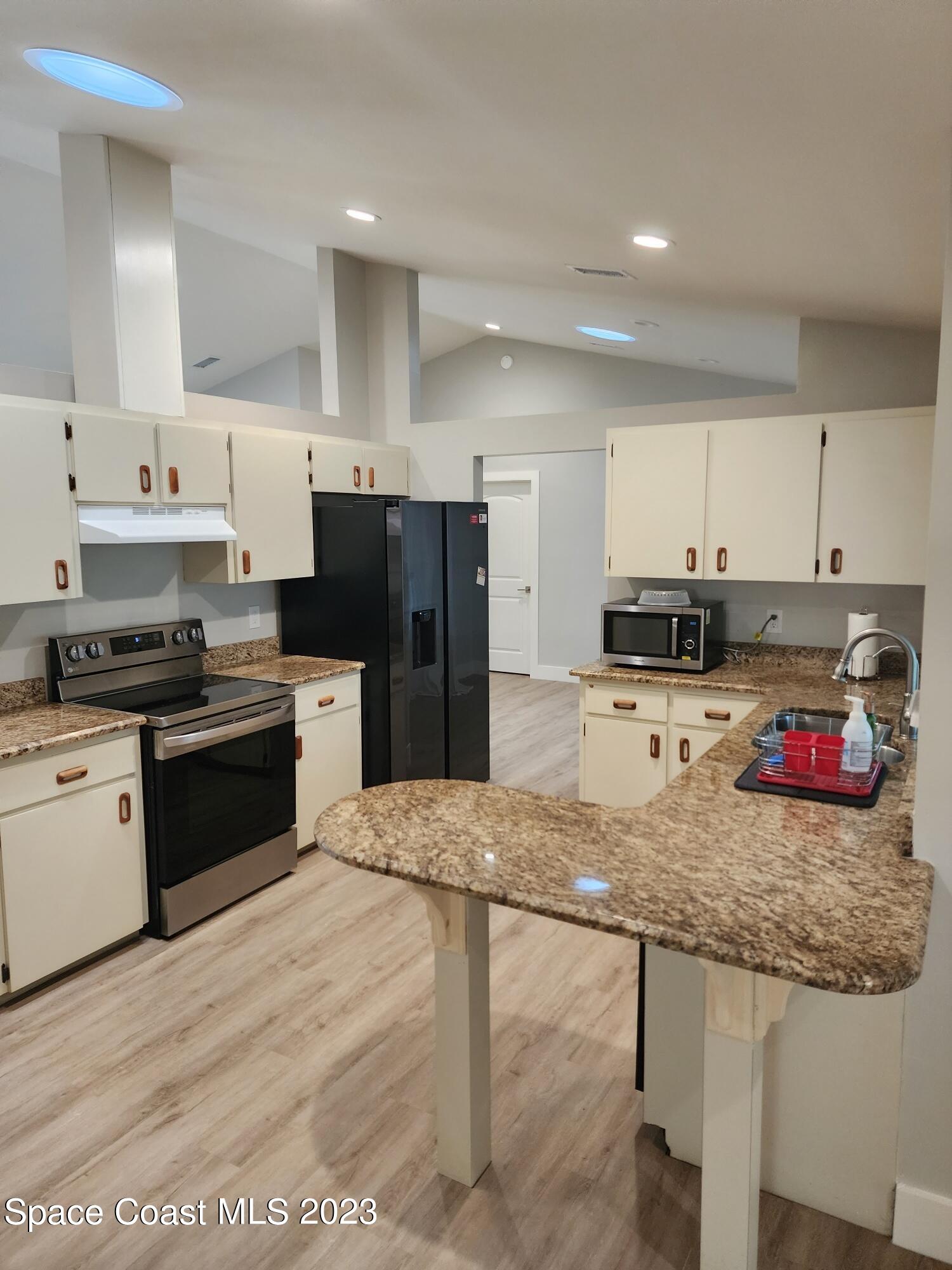 708 Fishtail Palm Boulevard Melbourne, FL 32901 - Photo 11 of 33 a kitchen with stainless steel appliances granite countertop a stove refrigerator sink and cabinets
