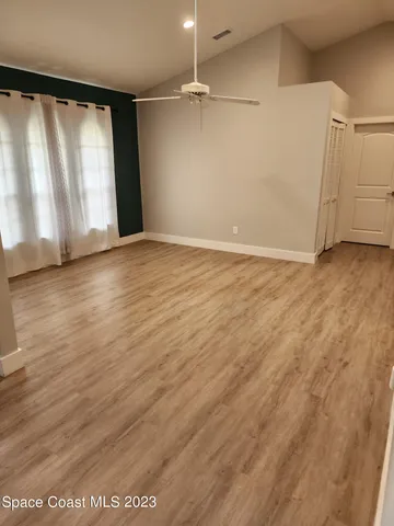 a view of an empty room with wooden floor