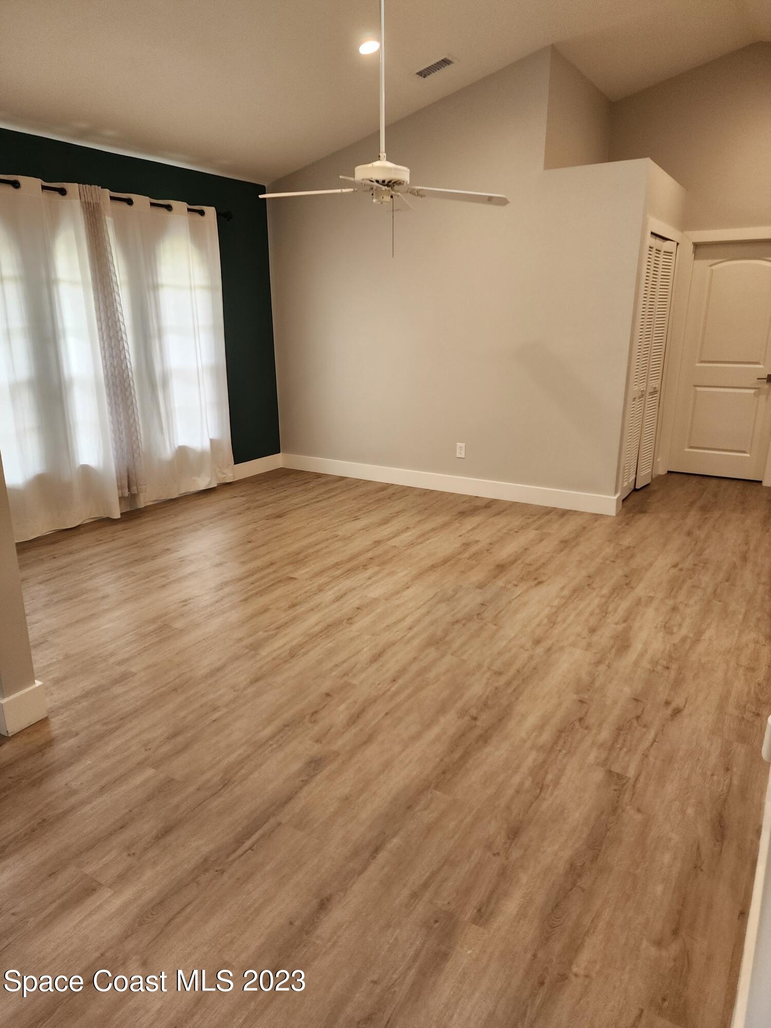 708 Fishtail Palm Boulevard Melbourne, FL 32901 - Photo 12 of 33 an empty room with wooden floor and windows