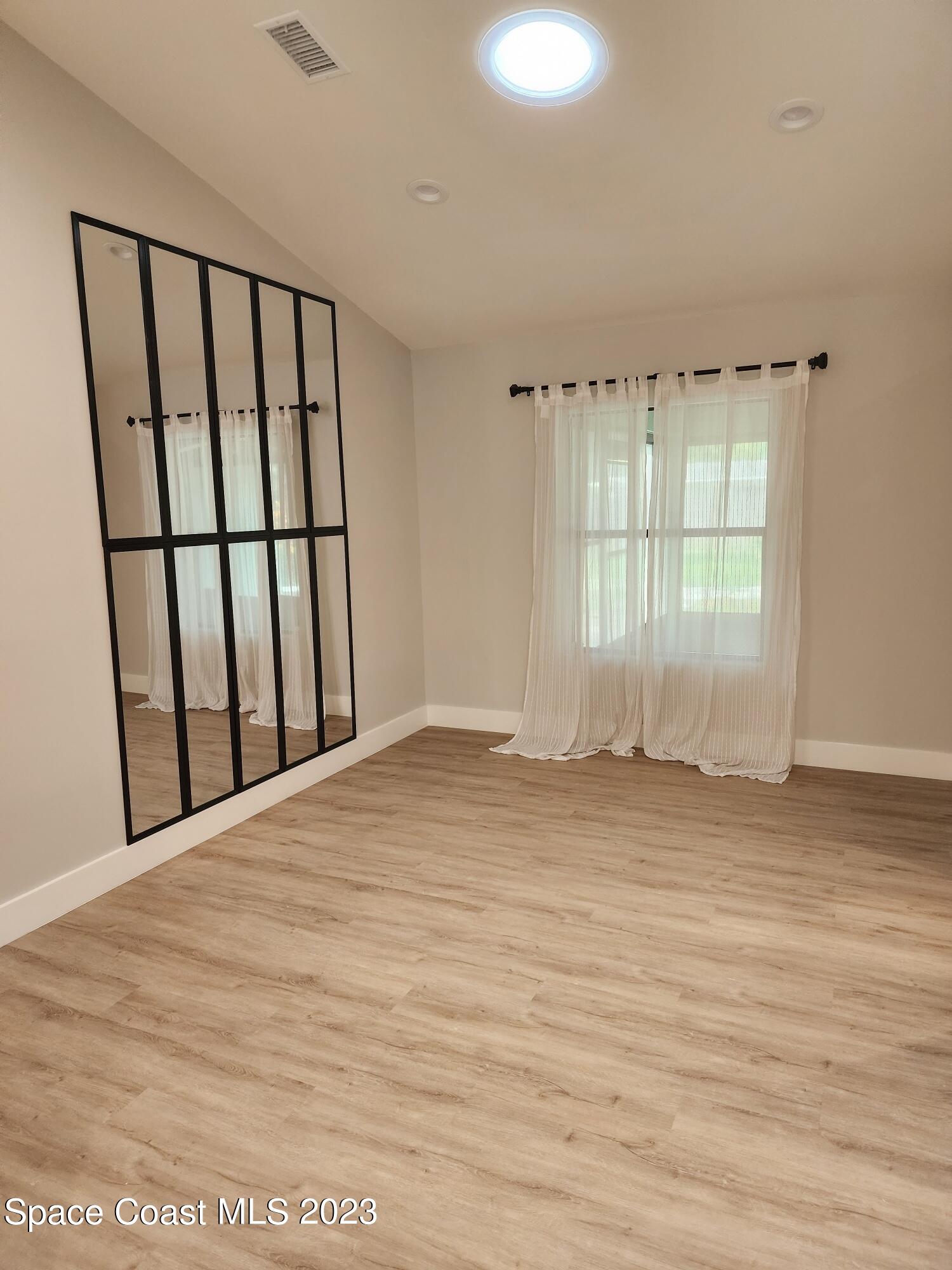 708 Fishtail Palm Boulevard Melbourne, FL 32901 - Photo 14 of 33 a view of an empty room with wooden floor and a window