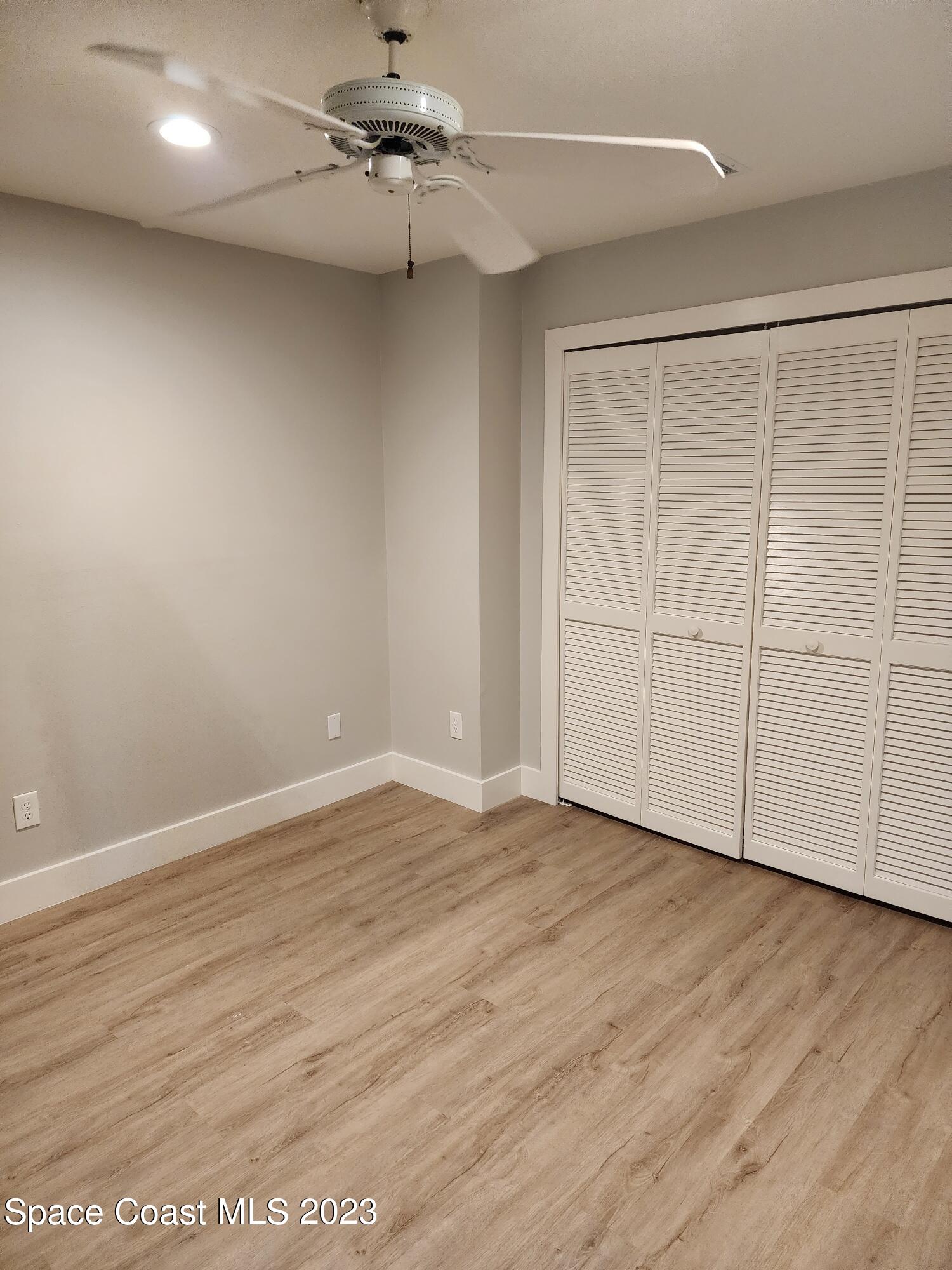 708 Fishtail Palm Boulevard Melbourne, FL 32901 - Photo 19 of 33 an empty room with wooden floor closet and windows