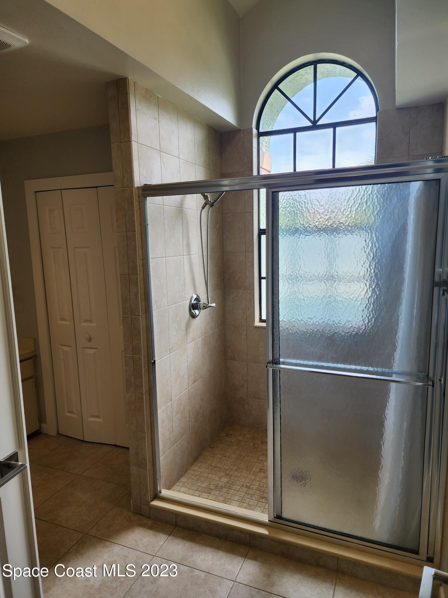 708 Fishtail Palm Boulevard Melbourne, FL 32901 - Photo 24 of 33 a bathroom with a glass door shower and a mirror
