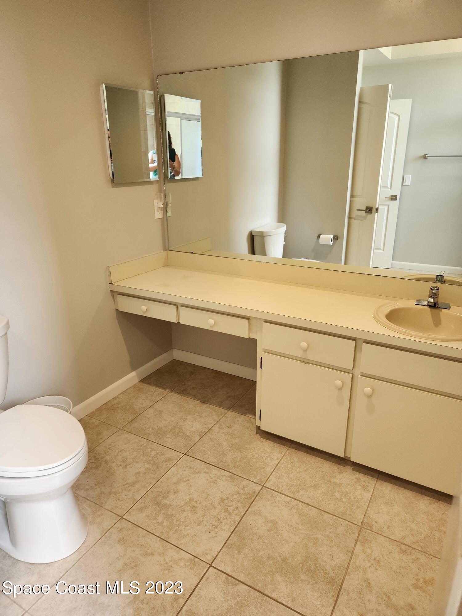 708 Fishtail Palm Boulevard Melbourne, FL 32901 - Photo 25 of 33 a bathroom with a sink toilet and mirror