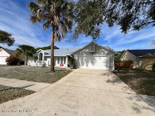708 Fishtail Palm Boulevard Melbourne, FL 32901 - Photo 3 of 33 a front view of a house with a yard and garage