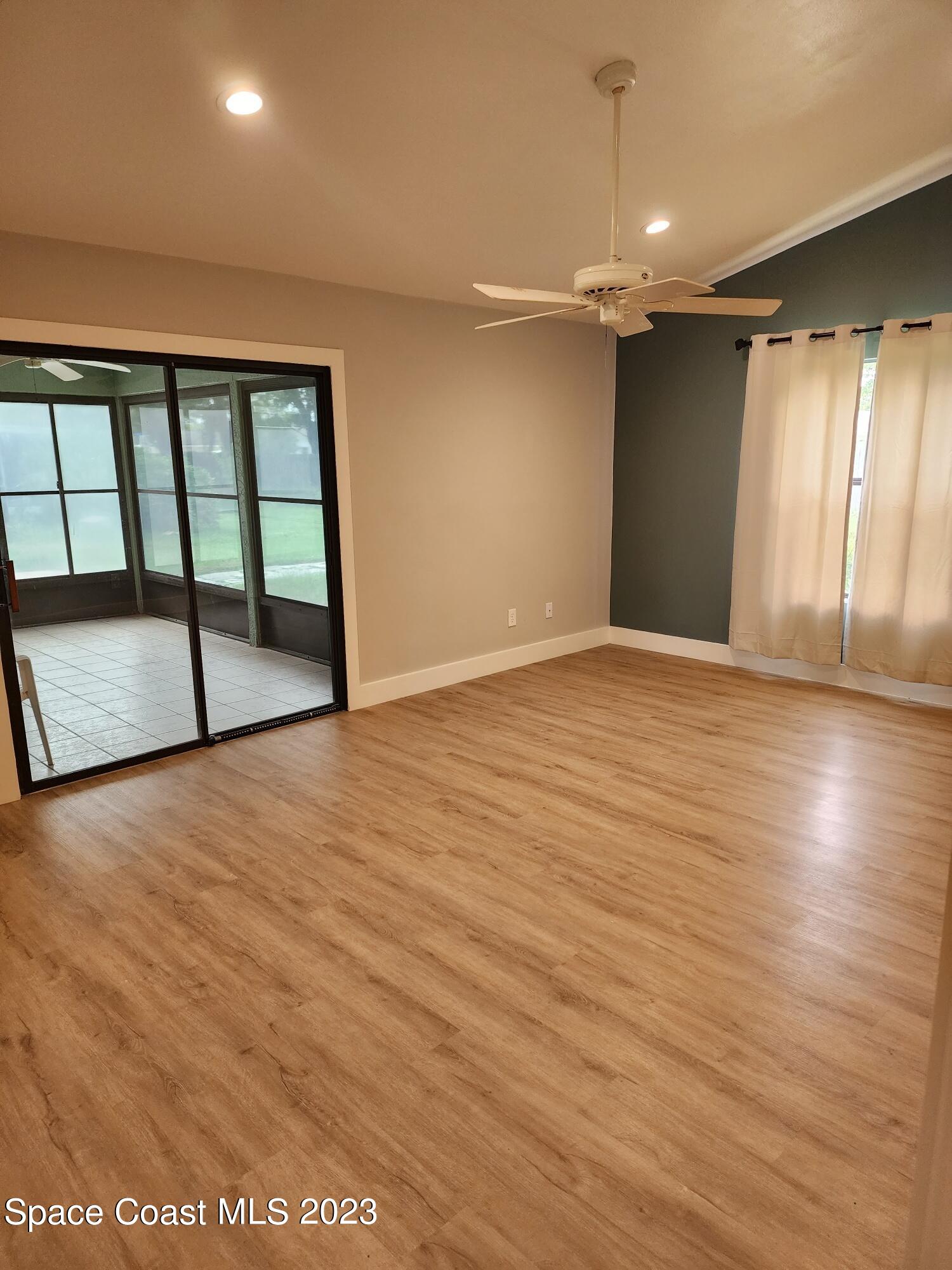 708 Fishtail Palm Boulevard Melbourne, FL 32901 - Photo 7 of 33 an empty room with wooden floor and windows