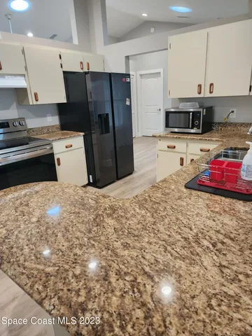 a kitchen with stainless steel appliances granite countertop a stove refrigerator sink and cabinets
