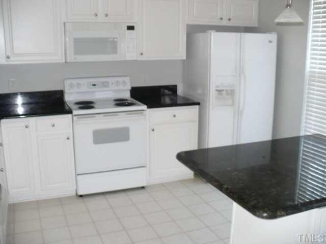 5316 Berry Creek Circle Raleigh, NC 27613 - Photo 7 of 9 a kitchen with a stove and white cabinets