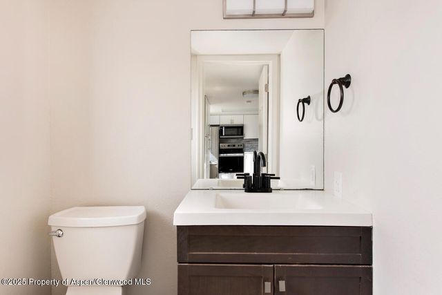a bathroom with a sink a toilet and mirror