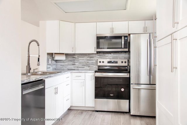 a kitchen with stainless steel appliances a stove microwave and sink