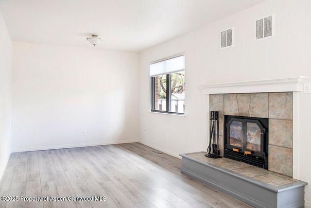 an empty room with a fireplace and window