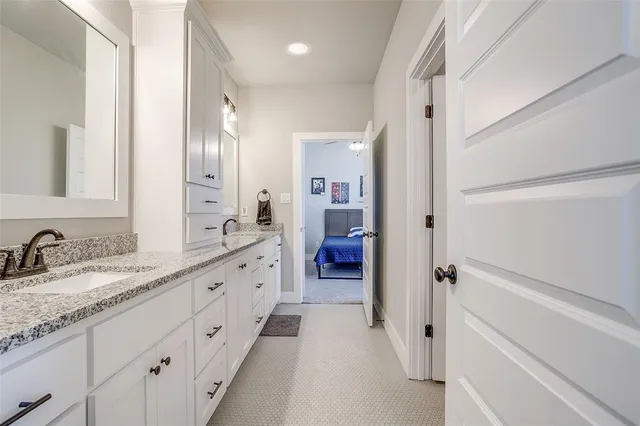 a spacious bathroom with a double vanity sink a mirror and a shower