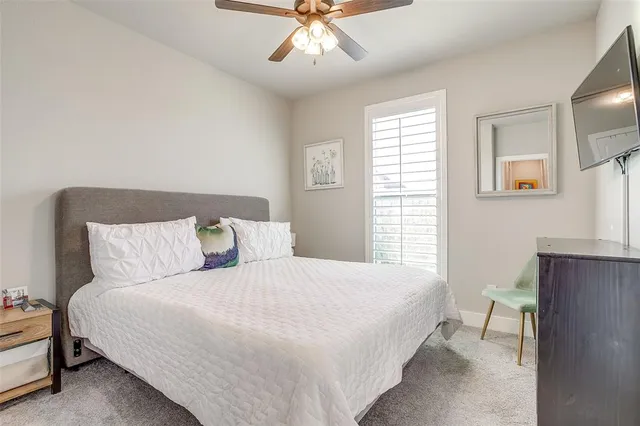 a large bed sitting in a bedroom next to a window and a chandelier