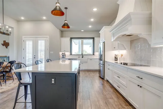 a kitchen with stainless steel appliances kitchen island granite countertop a sink and cabinets