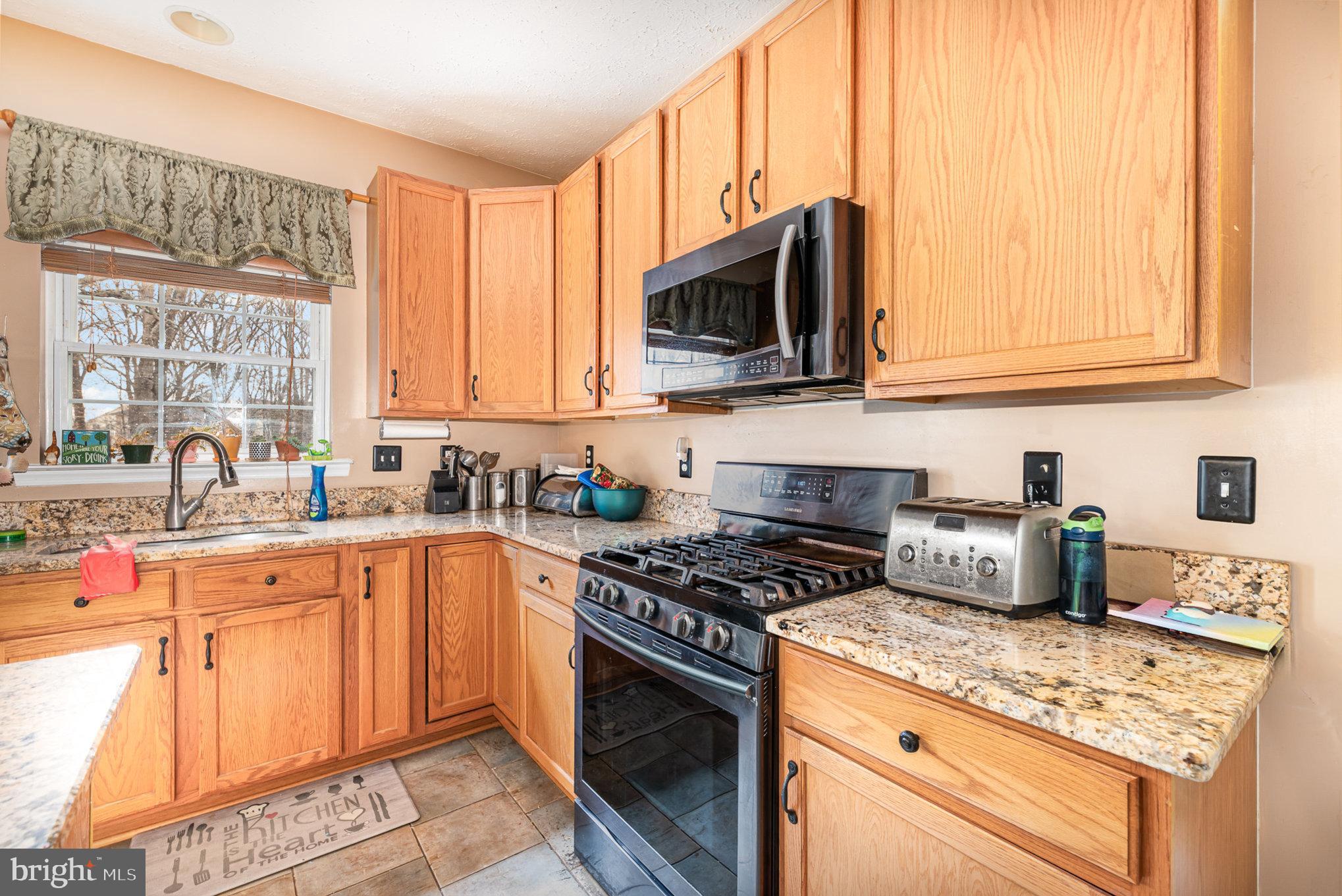145 West Heather Road Bel Air, MD 21014 - Photo 17 of 47 a kitchen with stainless steel appliances granite countertop a stove a sink and a microwave