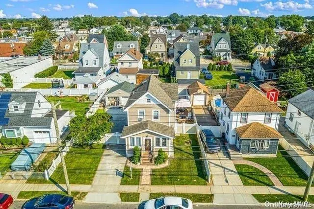 an aerial view of residential houses with outdoor space and trees