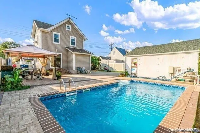 a view of a house with swimming pool and sitting area