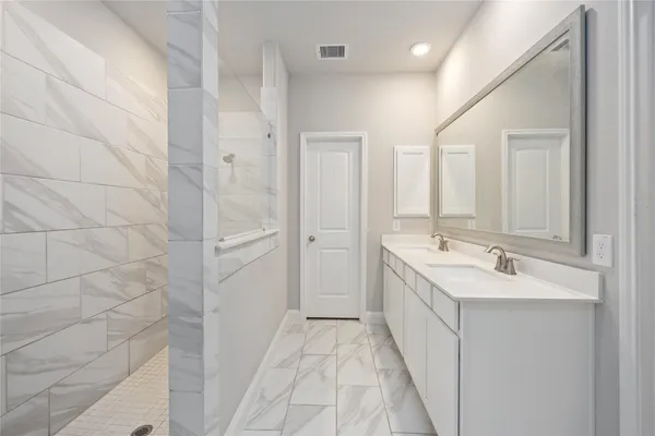 a bathroom with a double vanity sink and mirror
