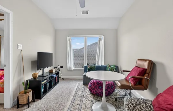 a living room with furniture a flat screen tv and a large window