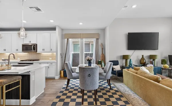 a living room with stainless steel appliances kitchen island granite countertop a stove a sink a dining table and chairs