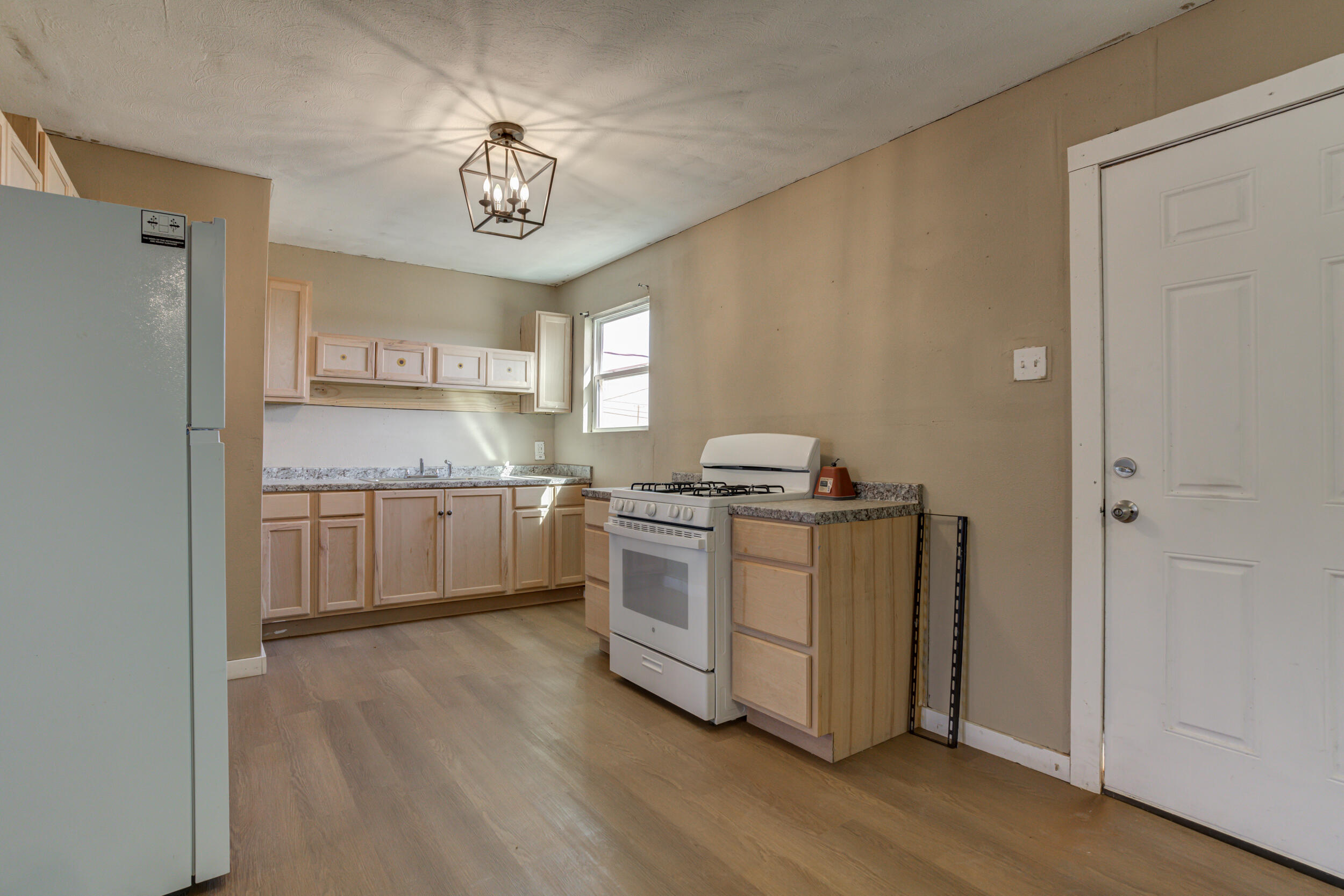 3204 East 2nd Street Lubbock, TX 79403 - Photo 12 of 34 a kitchen with a stove top oven cabinets a sink and a refrigerator