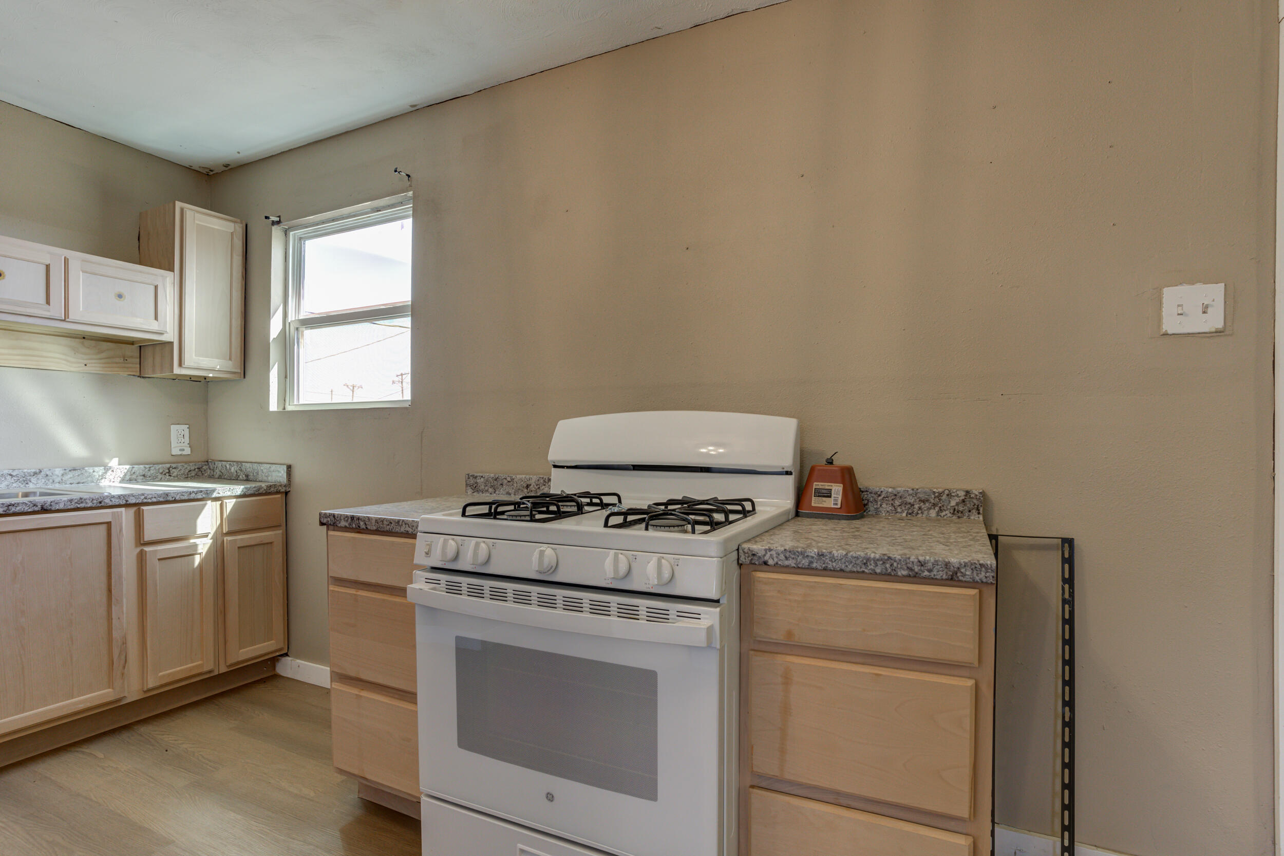 3204 East 2nd Street Lubbock, TX 79403 - Photo 13 of 34 a kitchen with a stove top oven sink and cabinets