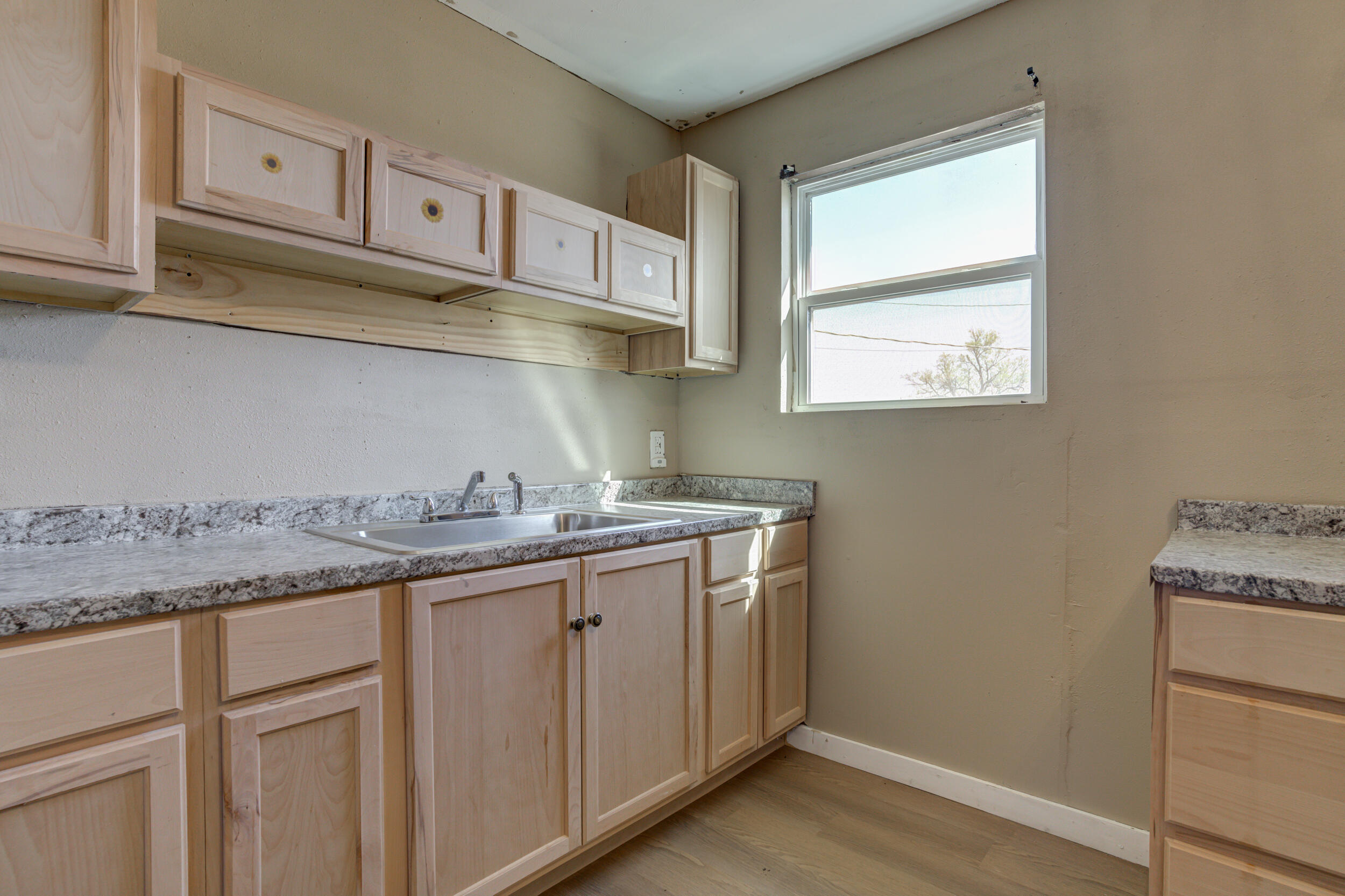 3204 East 2nd Street Lubbock, TX 79403 - Photo 14 of 34 a kitchen with stainless steel appliances granite countertop white cabinets sink and window