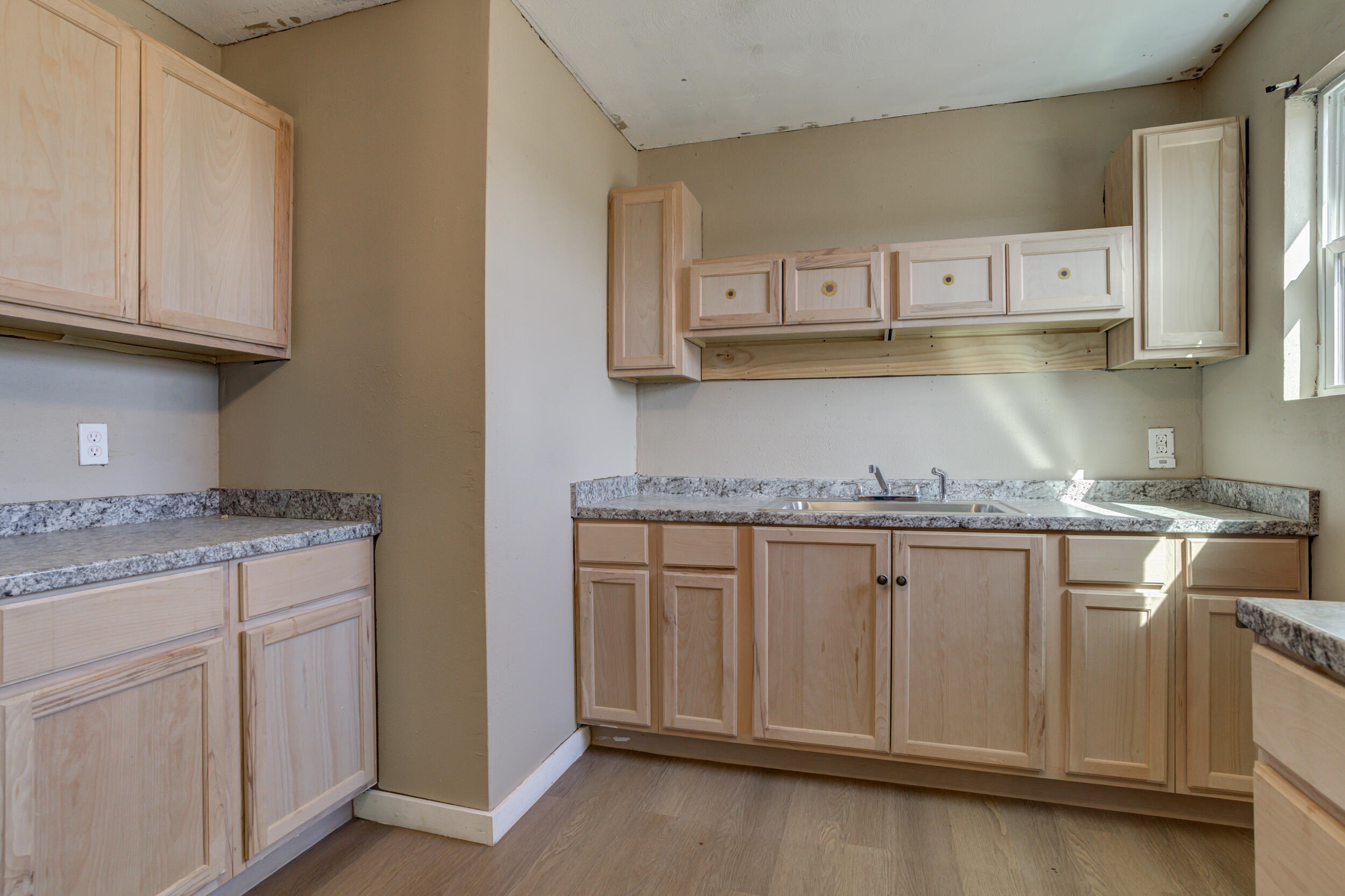 3204 East 2nd Street Lubbock, TX 79403 - Photo 15 of 34 a kitchen with granite countertop white cabinets and a sink