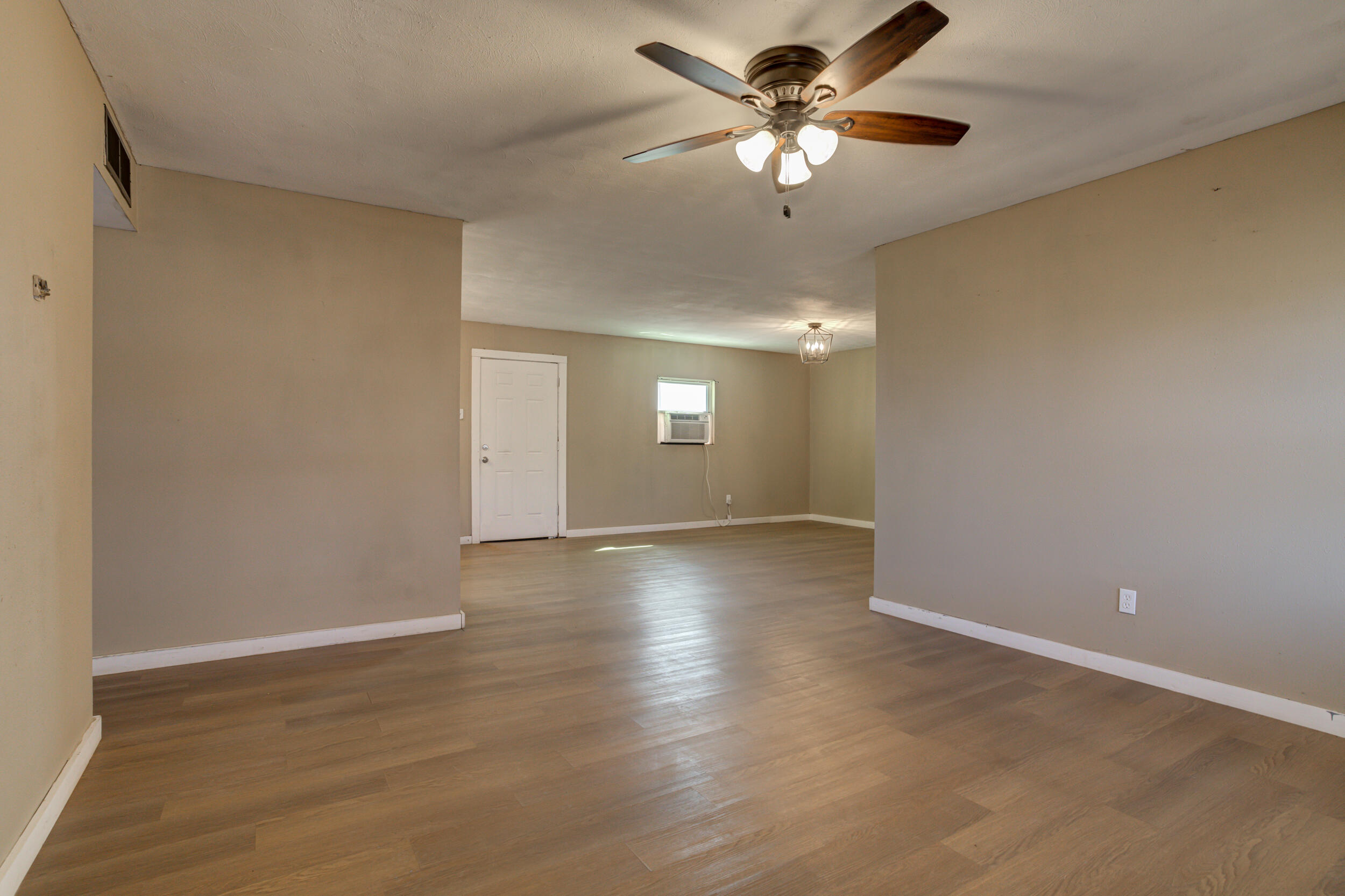 3204 East 2nd Street Lubbock, TX 79403 - Photo 9 of 34 an empty room with wooden floor and chandelier fan