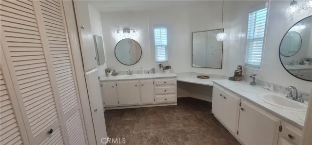 a spacious bathroom with a granite countertop toilet a sink and a mirror