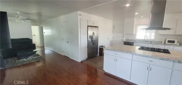 a kitchen with granite countertop white cabinets and white appliances