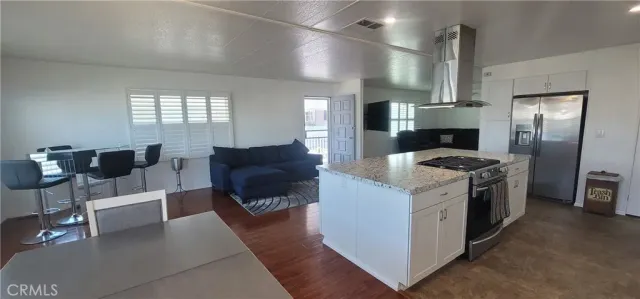 a kitchen with stainless steel appliances granite countertop a stove and a refrigerator