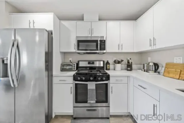 a kitchen with cabinets stainless steel appliances and a sink