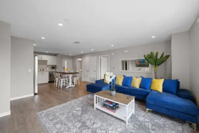 a living room with furniture and wooden floor