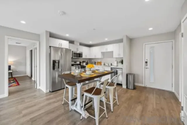 a kitchen with stainless steel appliances kitchen island granite countertop a refrigerator and a stove top oven