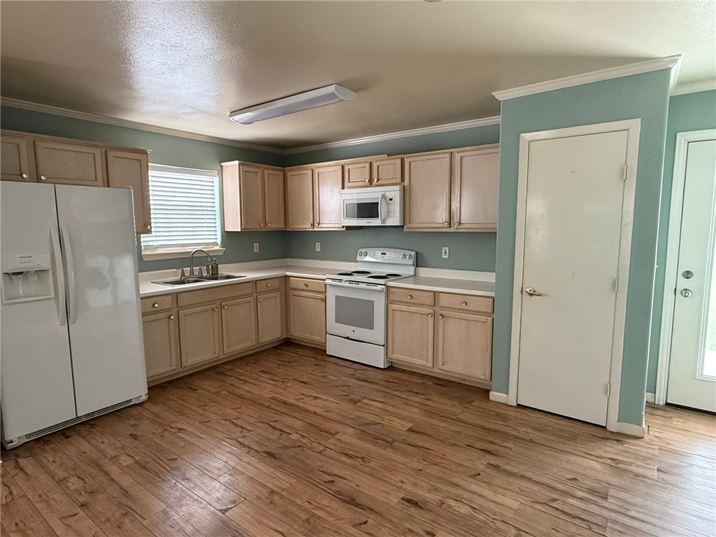 408 North Ave C Bishop, TX 78343 - Photo 3 of 12 a kitchen with white cabinets stainless steel appliances and a sink