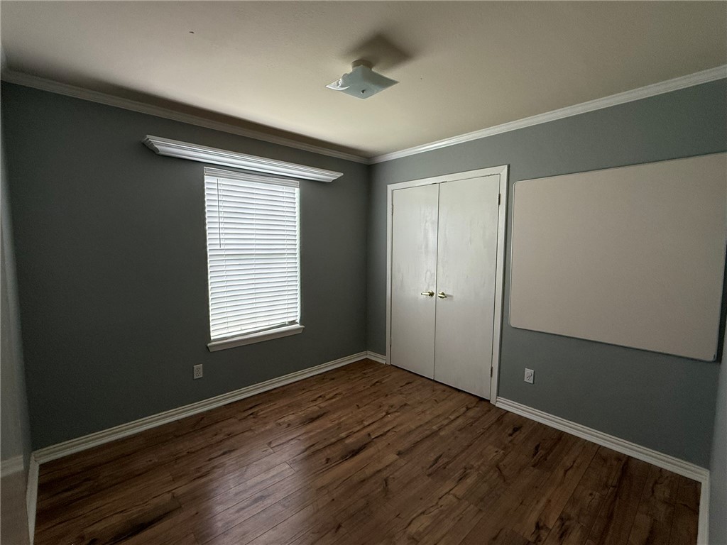 408 North Ave C Bishop, TX 78343 - Photo 6 of 12 a view of an empty room with wooden floor and a window