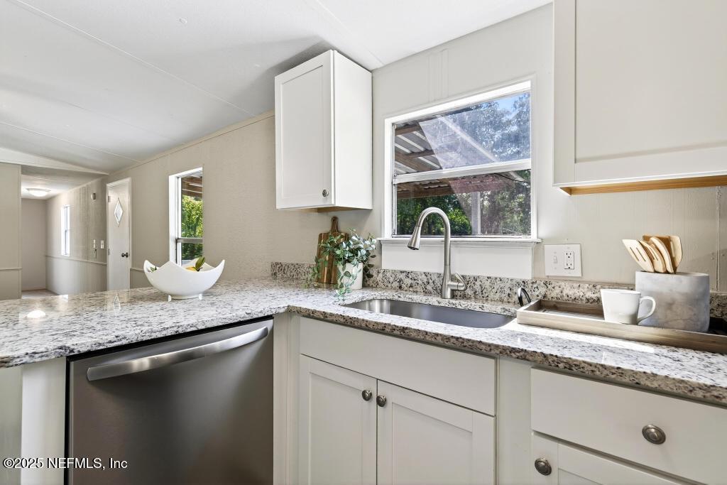 28 Neighbors Cove Road Orange Park, FL 32065 - Photo 19 of 56 a bathroom with a granite countertop sink and a window