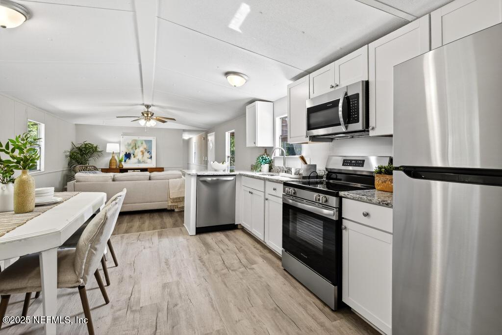 28 Neighbors Cove Road Orange Park, FL 32065 - Photo 23 of 56 a kitchen with a sink stainless steel appliances and white cabinets