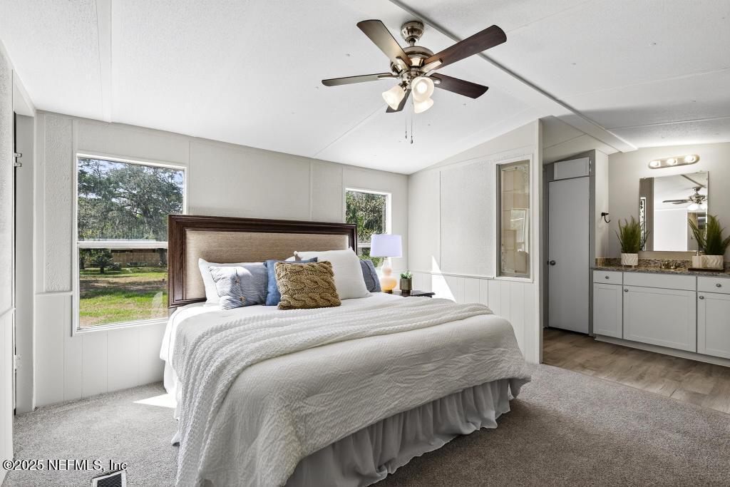 28 Neighbors Cove Road Orange Park, FL 32065 - Photo 32 of 56 a bedroom with a large bed and a chandelier