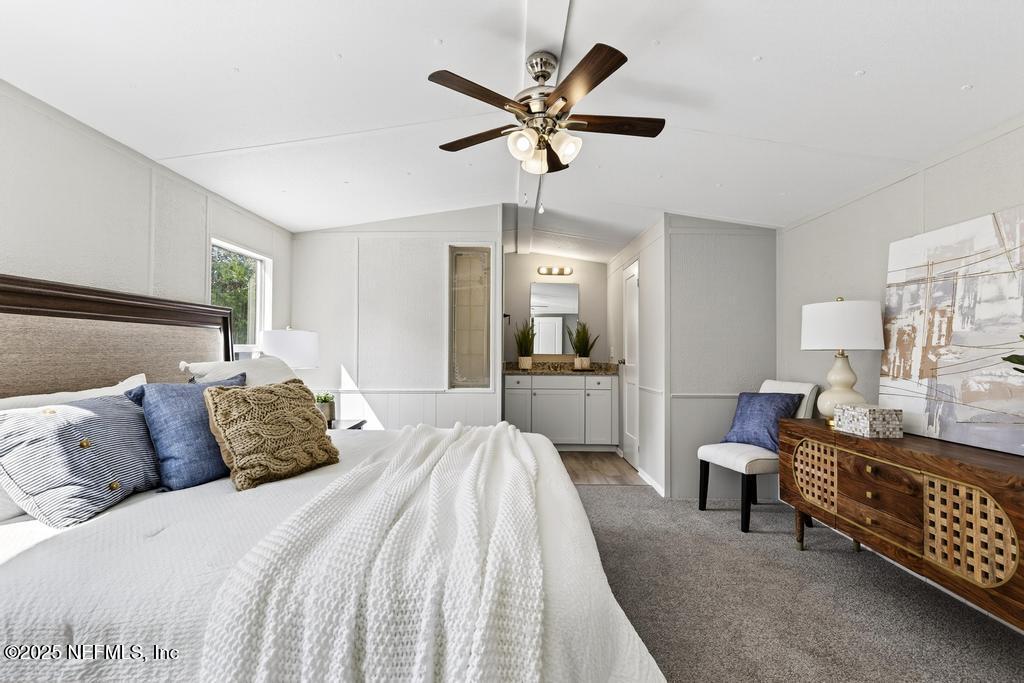 28 Neighbors Cove Road Orange Park, FL 32065 - Photo 34 of 56 a bedroom with a bed and a chandelier