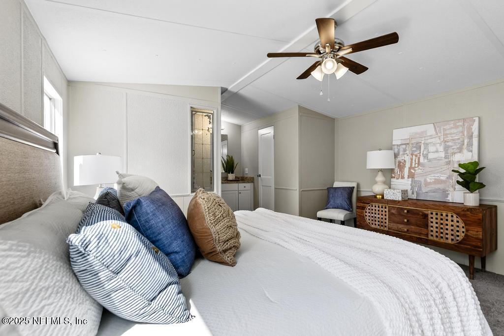 28 Neighbors Cove Road Orange Park, FL 32065 - Photo 35 of 56 a bedroom with a large bed and a chandelier